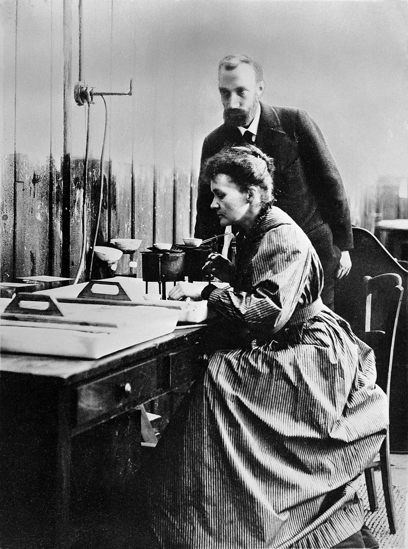 Pierre and Marie Curie at work in laboratory, attribution Wellcome Images CC BY 4.0 <https://creativecommons.org/licenses/by/4.0>, via Wikimedia Commons